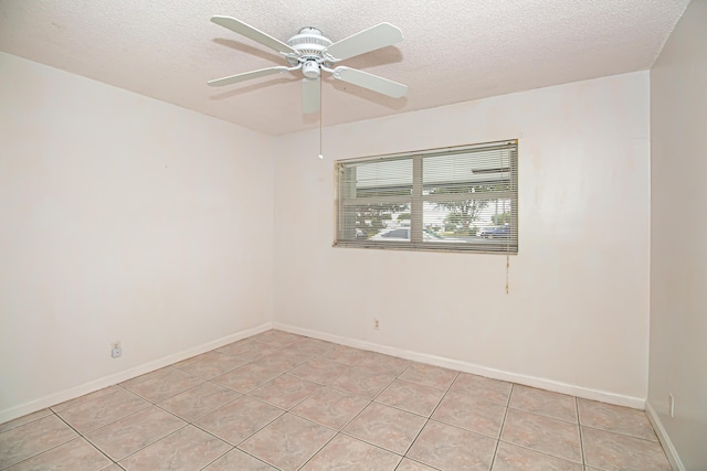 empty room with a textured ceiling, ceiling fan, and light tile patterned floors