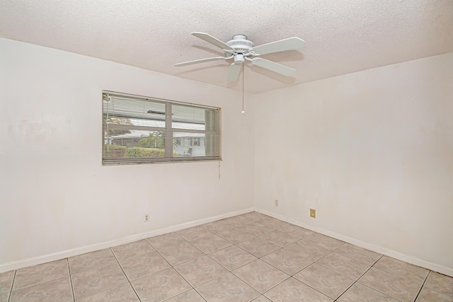 spare room featuring a textured ceiling, ceiling fan, and light tile patterned floors