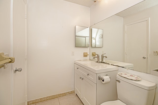 bathroom featuring tile patterned floors, vanity, and toilet