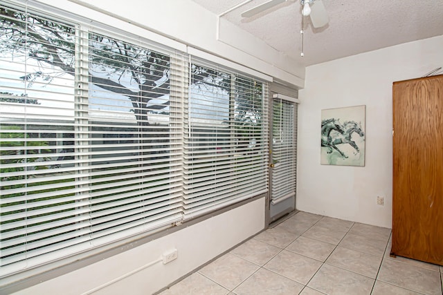 empty room featuring a textured ceiling and light tile patterned floors