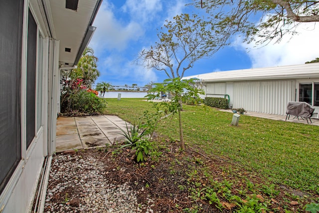 view of yard featuring a water view and a patio