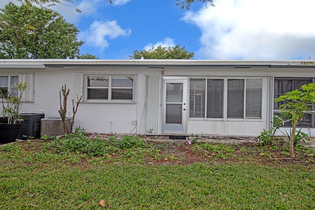 view of front of property featuring a front yard and central AC