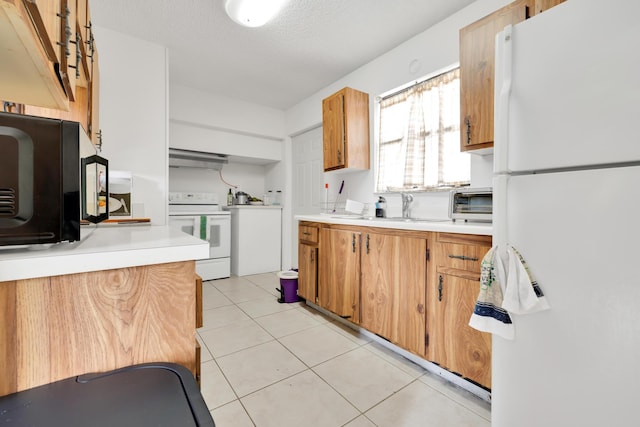 kitchen with white appliances, a textured ceiling, light tile patterned floors, and sink