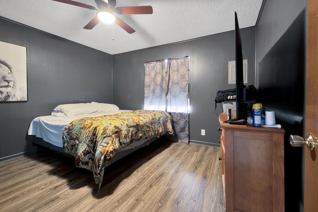 bedroom featuring ceiling fan, a textured ceiling, and hardwood / wood-style flooring