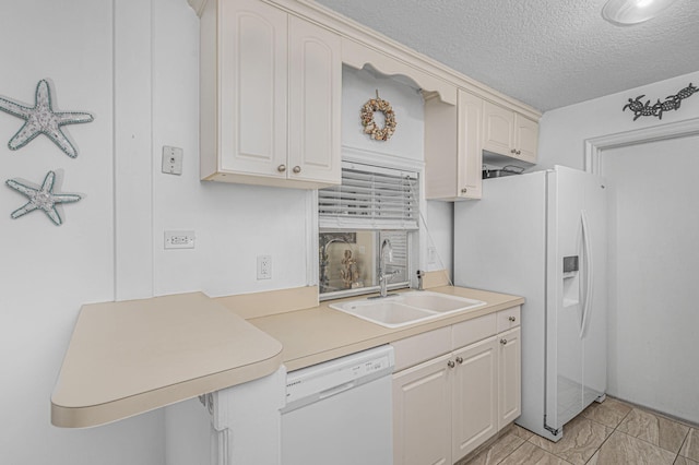 kitchen with white appliances, a textured ceiling, and sink