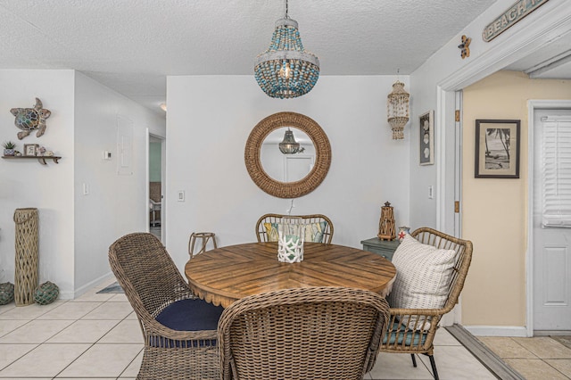 dining area with a textured ceiling, an inviting chandelier, and light tile patterned floors