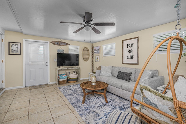 living room featuring a textured ceiling, ceiling fan, and light tile patterned floors