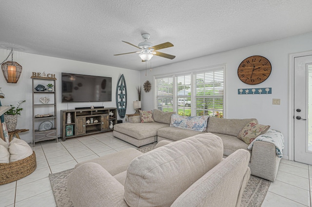 living room with a textured ceiling, ceiling fan, and light tile patterned floors