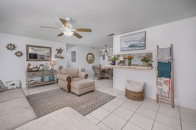 tiled living room featuring a textured ceiling and ceiling fan