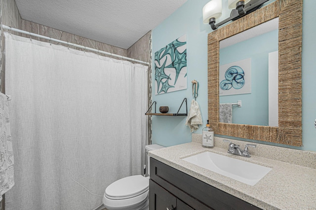 bathroom with toilet, vanity, and a textured ceiling