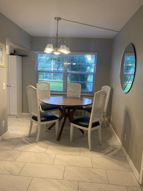 dining area with light tile patterned floors and a notable chandelier