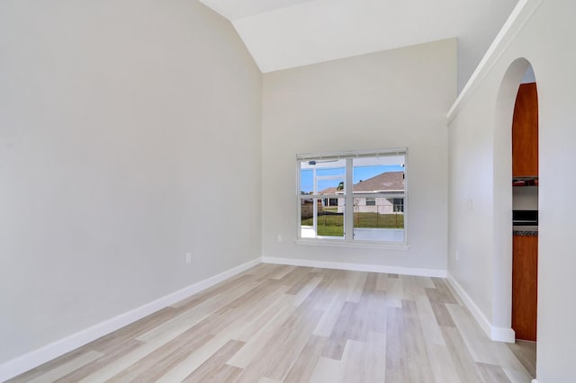 spare room with light hardwood / wood-style flooring and lofted ceiling