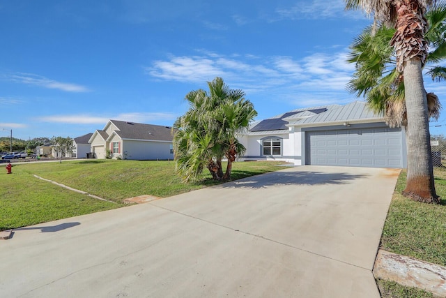 single story home featuring solar panels, a front lawn, and a garage