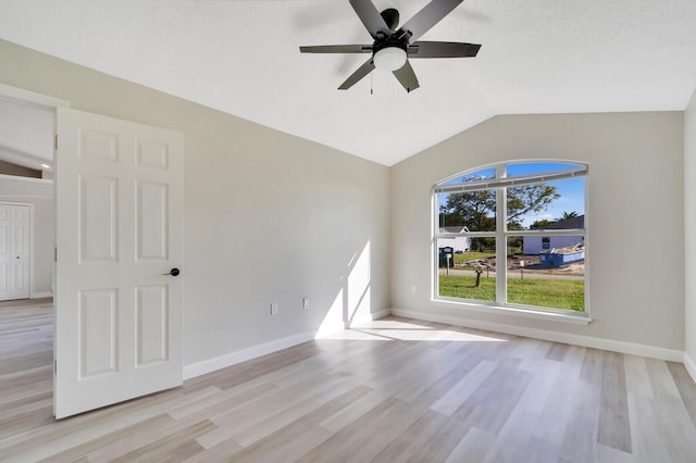 empty room with lofted ceiling, ceiling fan, and light hardwood / wood-style flooring