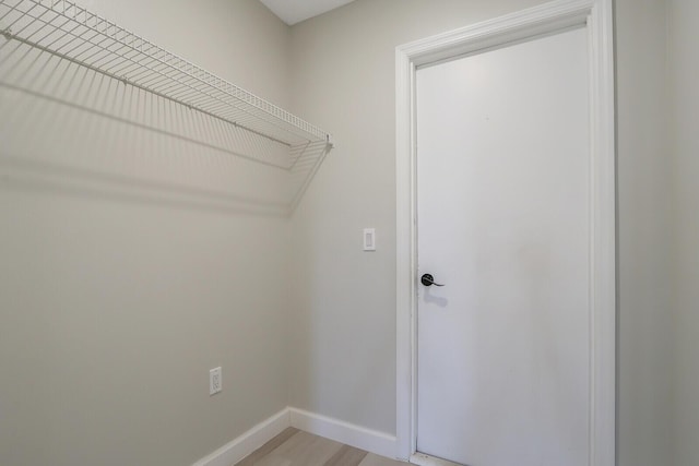 clothes washing area with light hardwood / wood-style floors