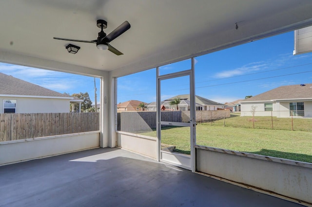 unfurnished sunroom featuring ceiling fan