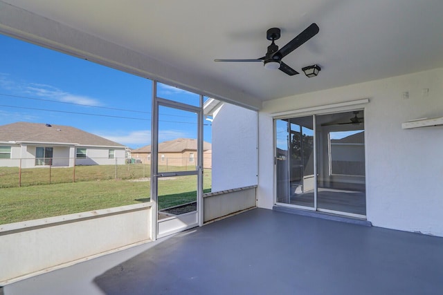 unfurnished sunroom with ceiling fan