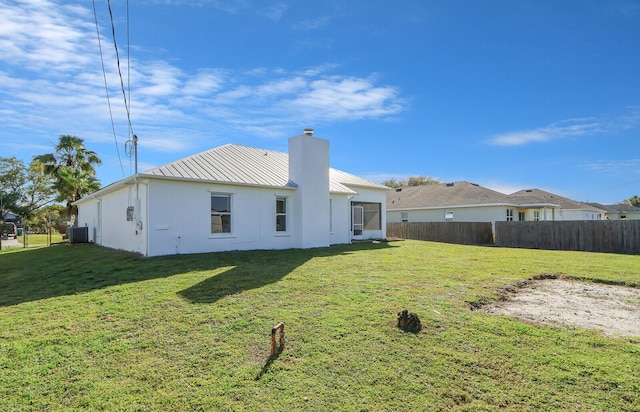 back of house featuring cooling unit and a yard