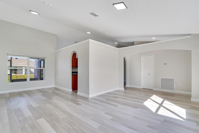 empty room with light wood-type flooring and lofted ceiling