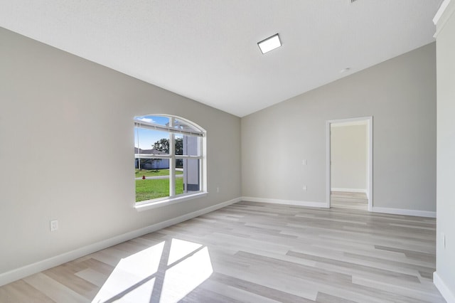 unfurnished room with light hardwood / wood-style floors and lofted ceiling