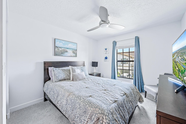 bedroom with ceiling fan, light carpet, and a textured ceiling