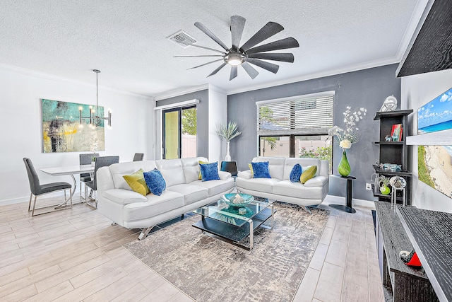 living room with ceiling fan with notable chandelier, a textured ceiling, ornamental molding, and light hardwood / wood-style floors