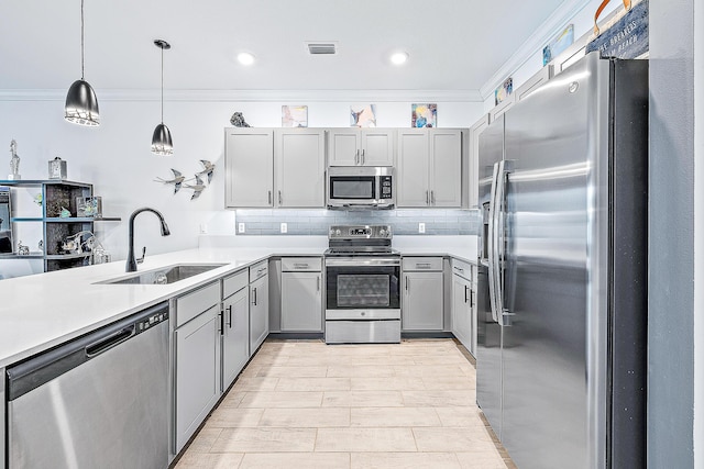 kitchen featuring appliances with stainless steel finishes, gray cabinetry, sink, decorative light fixtures, and backsplash