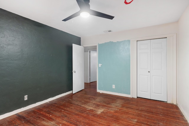 unfurnished bedroom with ceiling fan, dark hardwood / wood-style flooring, and a closet