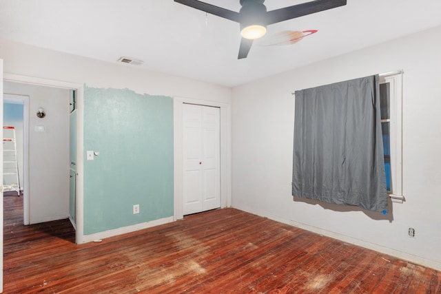 unfurnished bedroom featuring a closet, ceiling fan, and dark hardwood / wood-style flooring