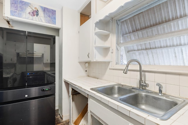 kitchen featuring sink, tile counters, decorative backsplash, and white cabinets