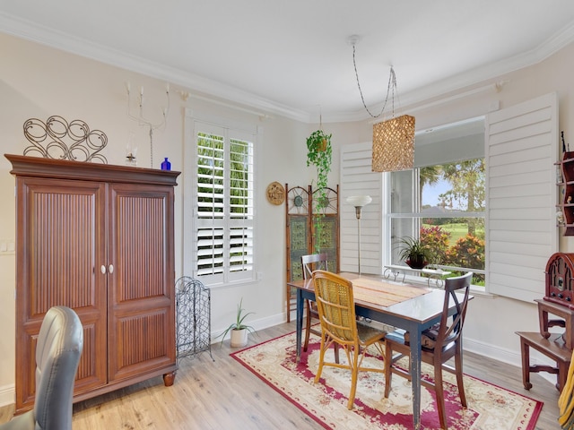 dining area with light wood-type flooring and ornamental molding