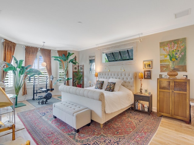 bedroom featuring ornamental molding and light hardwood / wood-style floors