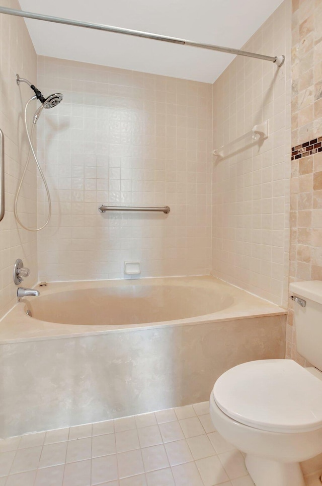 bathroom featuring toilet, tile patterned flooring, and tiled shower / bath combo