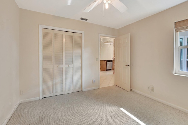 unfurnished bedroom with a closet, ceiling fan, and light colored carpet