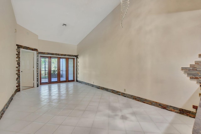 unfurnished room featuring high vaulted ceiling, french doors, and light tile patterned floors