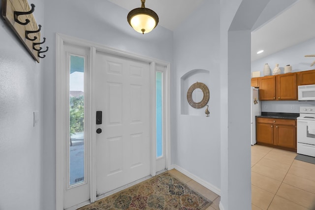 entryway featuring vaulted ceiling and light tile patterned floors