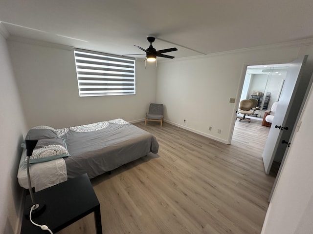 bedroom featuring ceiling fan, light hardwood / wood-style floors, and crown molding