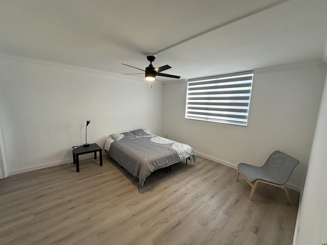 bedroom with ceiling fan, light hardwood / wood-style floors, and ornamental molding