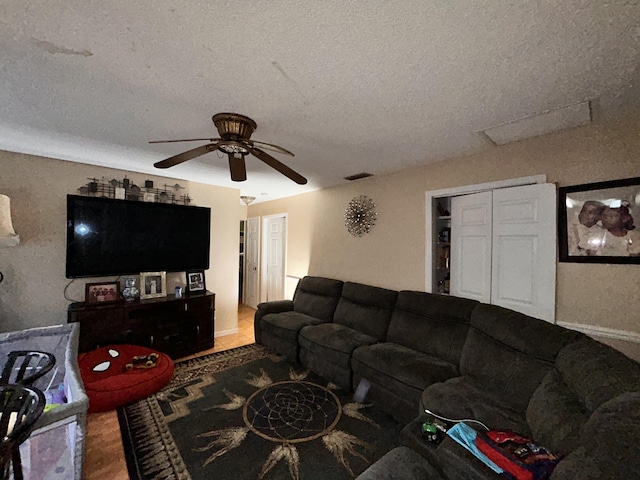 living room featuring a textured ceiling and ceiling fan