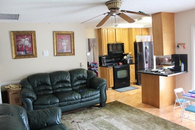 living room with a textured ceiling, ceiling fan, and light tile patterned flooring