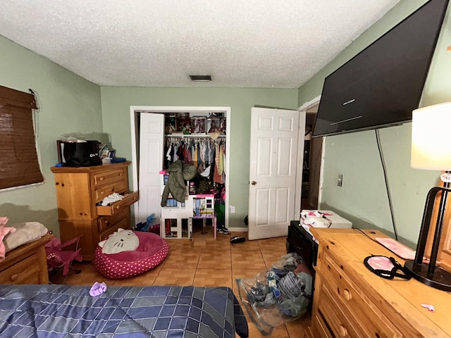 tiled bedroom featuring a textured ceiling and a closet