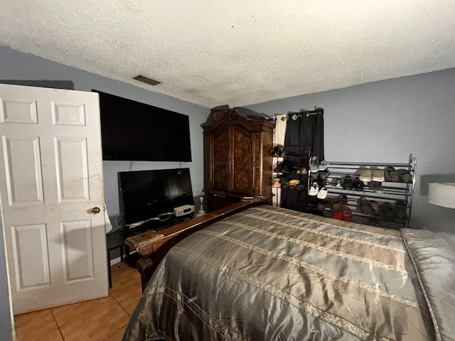 bedroom featuring tile patterned floors and a textured ceiling