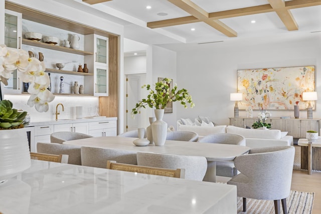 living room with beamed ceiling, sink, coffered ceiling, and light hardwood / wood-style floors