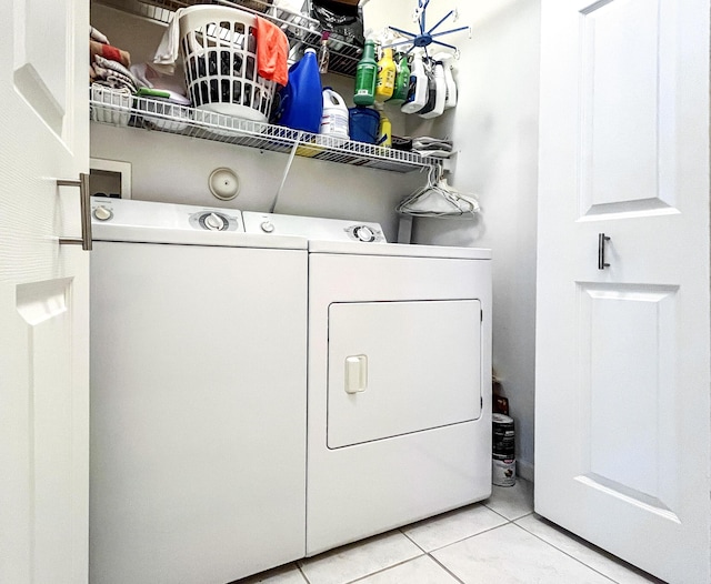 clothes washing area with light tile patterned floors and independent washer and dryer