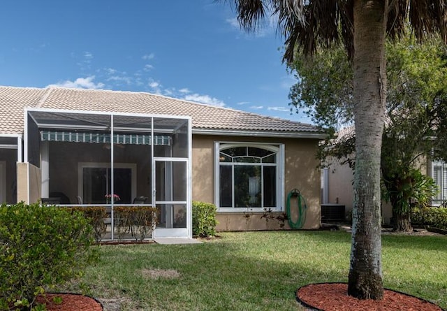 back of property featuring a lawn and central air condition unit