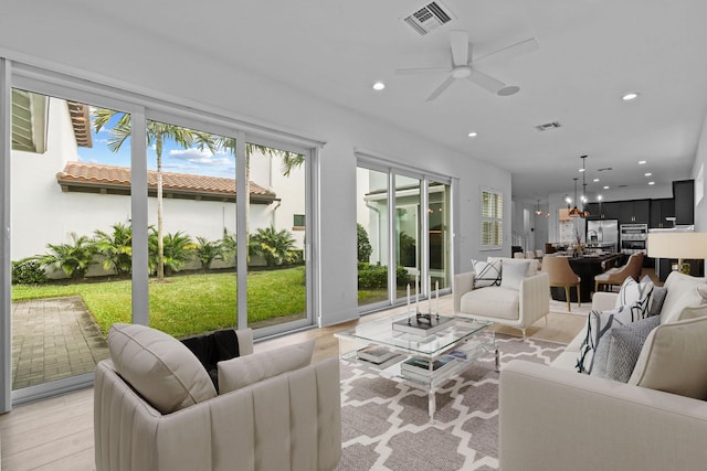 living room with ceiling fan and light wood-type flooring