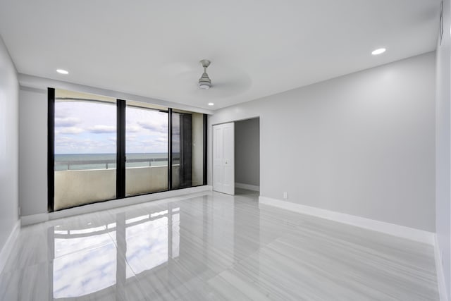 spare room with ceiling fan and a water view