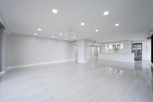 unfurnished living room featuring ceiling fan