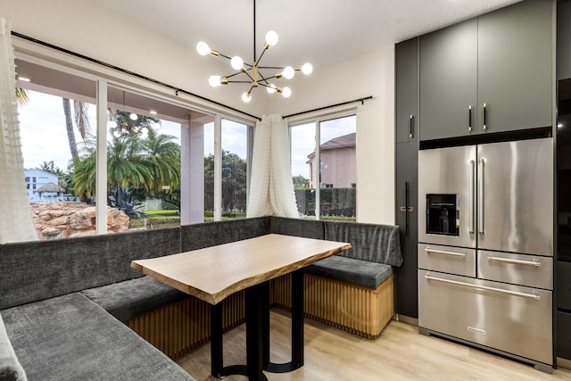 dining room featuring light hardwood / wood-style floors, breakfast area, and an inviting chandelier