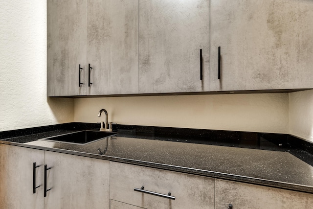 kitchen featuring dark stone countertops and sink